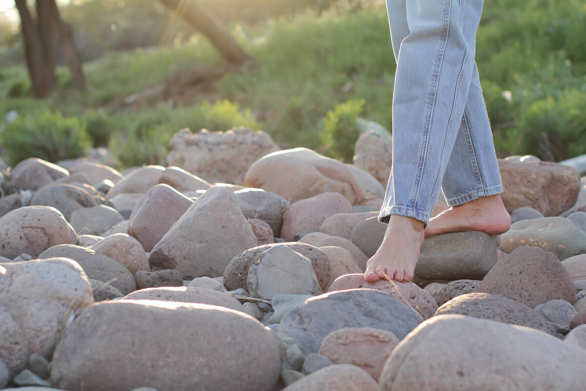 Belinda's barefeet stepping across large stones